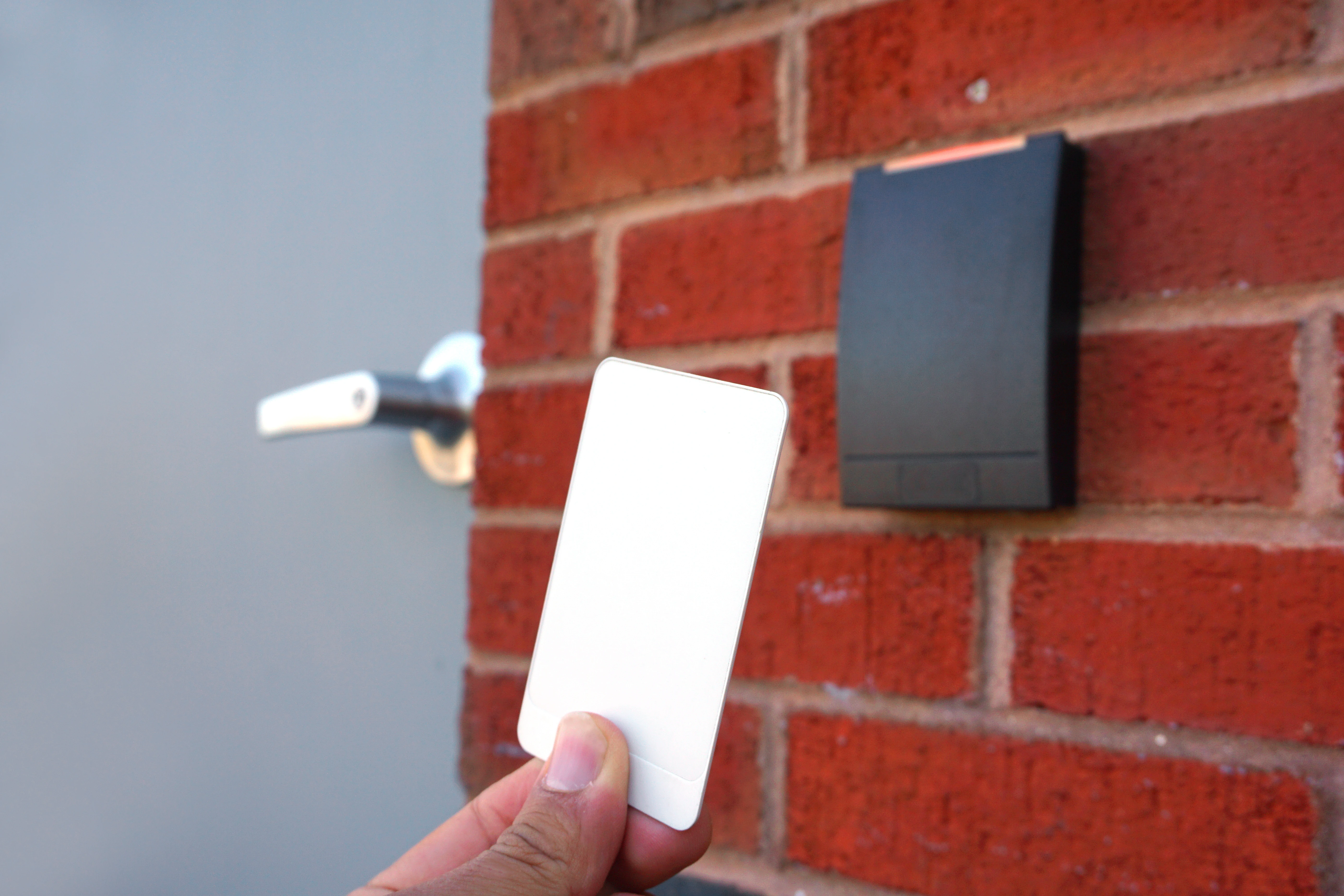 a person presenting an access control card to a reader at a door