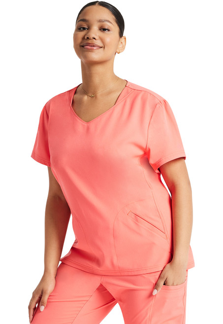 The Break On Through V-Neck Top features puff sleeves, a rounded v-neck, and a high-low hem. It includes two welt pockets and front vents, combining style and comfort for busy healthcare professionals.
