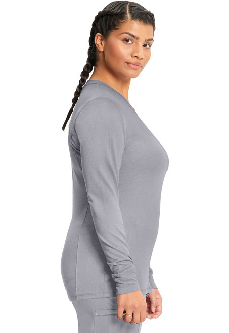 The Left View of the Infinity Long Sleeve Underscrub Knit Tee CK782 highlights comfy, functional medical uniforms. Made of 95% polyester and 5% spandex, these scrubs have a flattering round neckline and knit cuffs, ideal for active work.