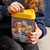 The Smart Saver Bank held by a child who's putting money into the Spend section