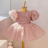 Discover enchanting elegance with our girls' pink dress. Adorned with beaded sequins on the bodice and featuring a puffy tulle skirt and sleeves, this charming outfit is lined with soft cotton fabric for ultimate comfort. Complete with a delightful bow detail at the back, perfect for any special occasion