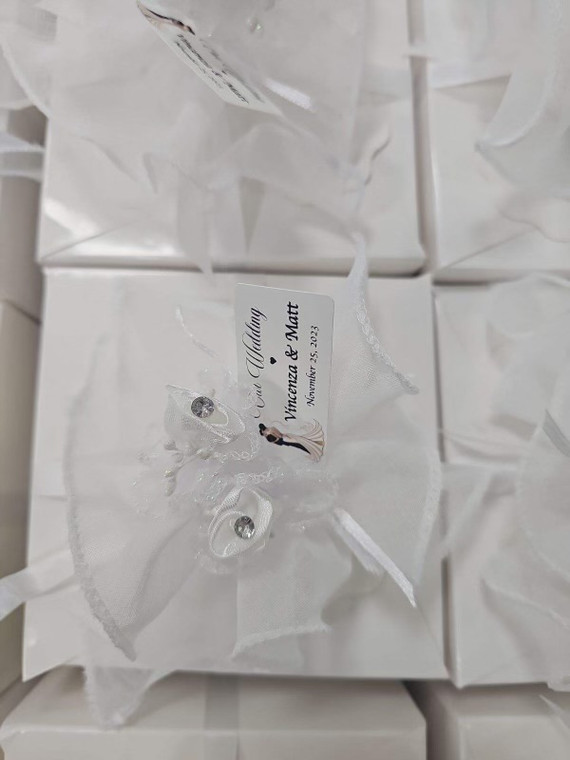 Elegant white wedding favor box with a decorative bow, embellished with rhinestones, perfect for party celebrations.