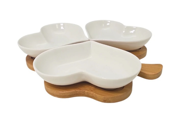 Four heart-shaped bowls elegantly arranged on a bamboo stand, perfect for serving appetizers at weddings or bridal showers.