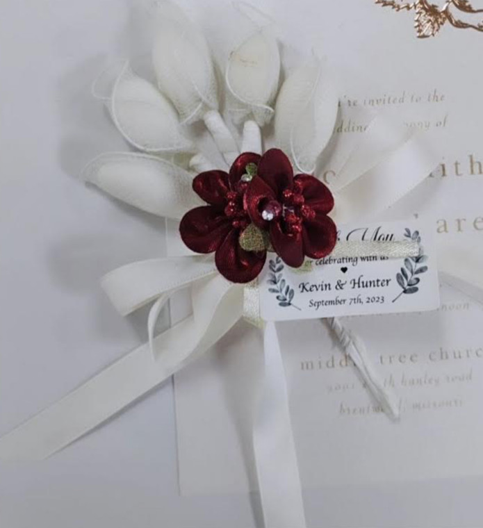 A beautiful bouquet of white flowers adorned with red ribbons, perfect for wedding favors and bridal showers.