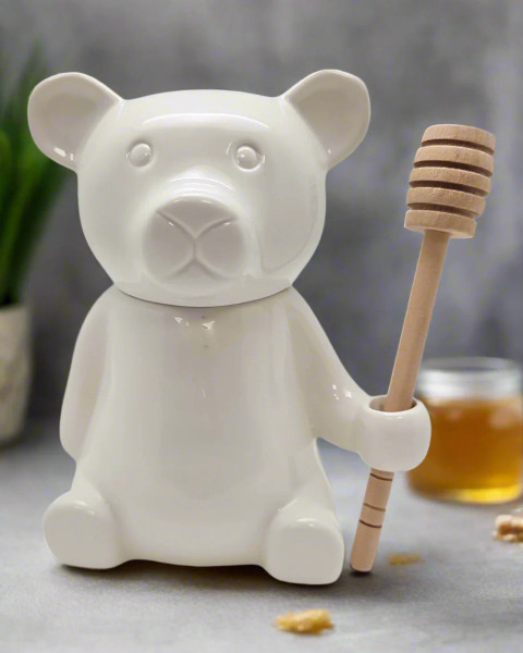A delightful white bear clutches a wooden stick, perfect for adding a touch of whimsy to your celebrations and kitchen decor.