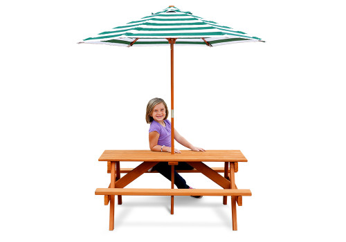 child sitting at picnic table with umbrella