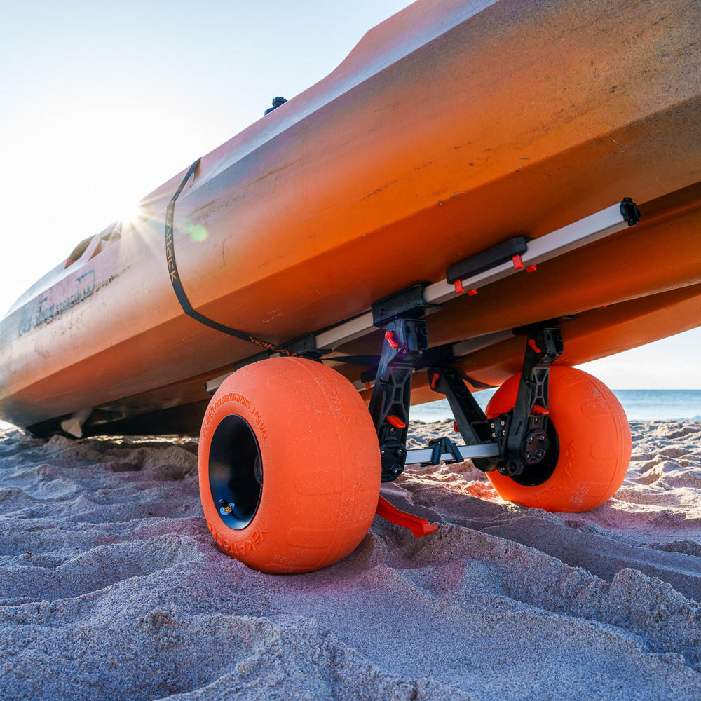 Lifestyle view of the TowNStow Sand Tire, Single holding kayak on sand