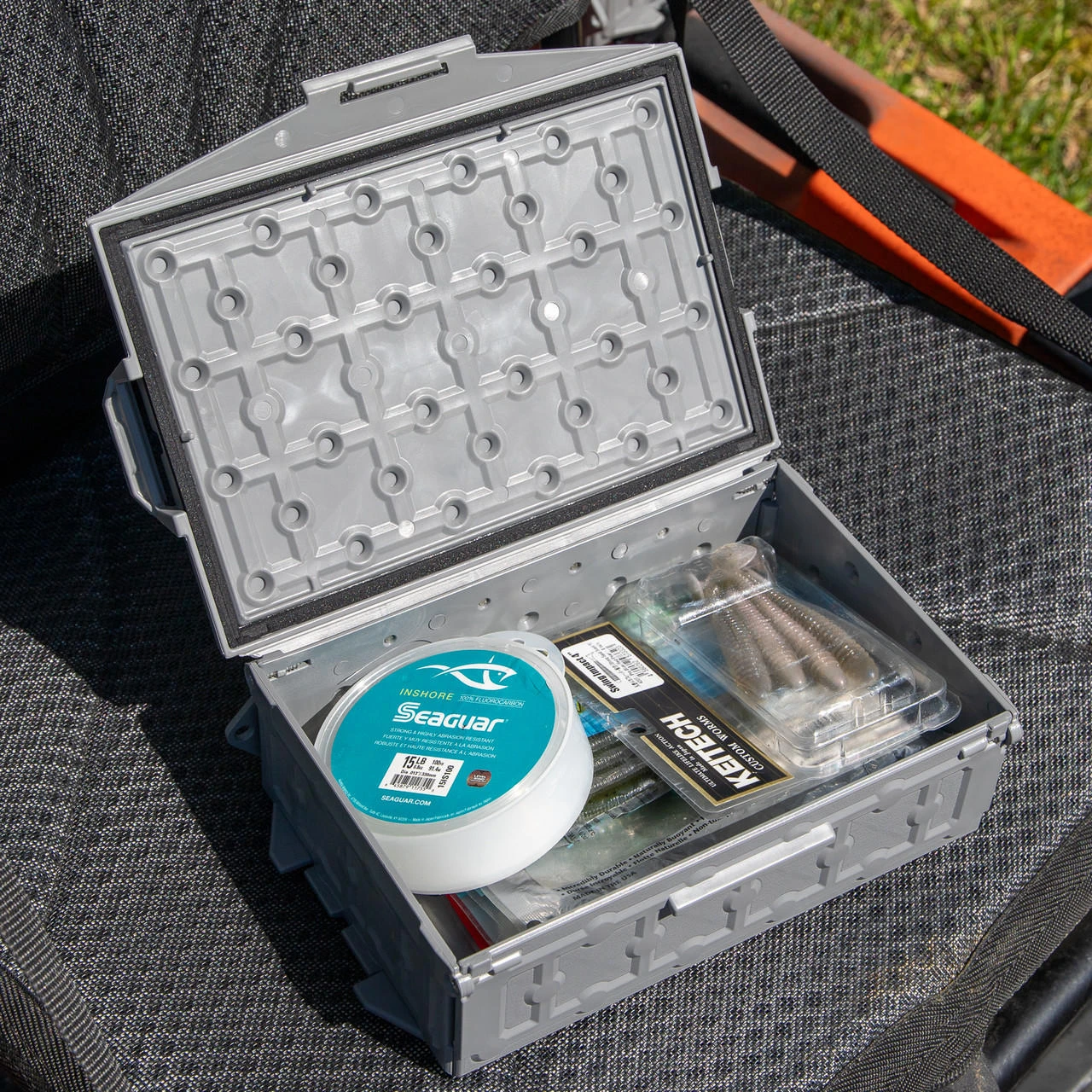Top angled lifestyle view of the TracPak Stackable Storage Box, Spare Box, Battleship Grey wit lid opened and stuff inside