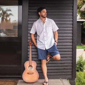 Man leaning on wall outside next to guitar wearing Renegade Cotton Ripstop Short in Big Dipper Blue