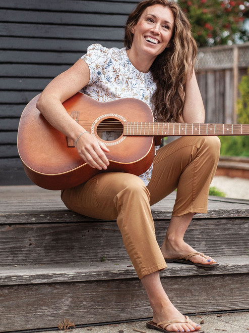 Woman sitting on porch with guitar wearing Reagan Cargo Crop Pant in dijon yellow color