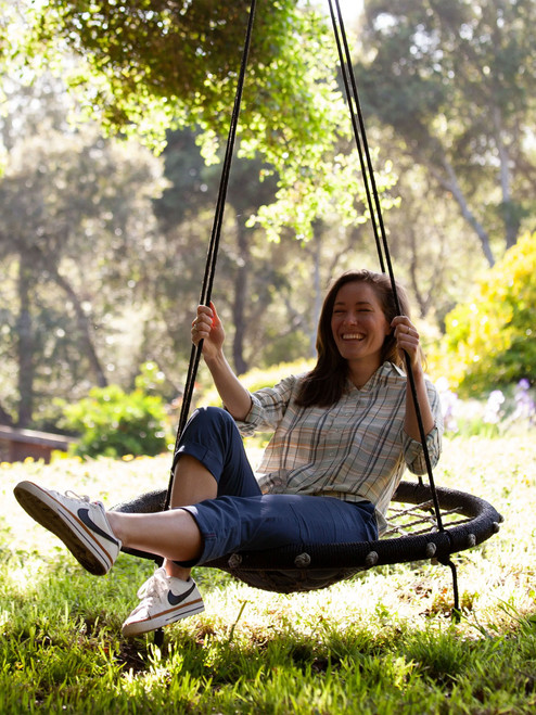 Woman sitting in tire swing wearing Reagan Cargo Crop Pant in dark blue