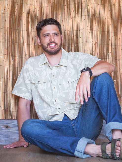 Man sitting on ground in sandals wearing Liam Pearl Snap Printed Shirt in Moss green