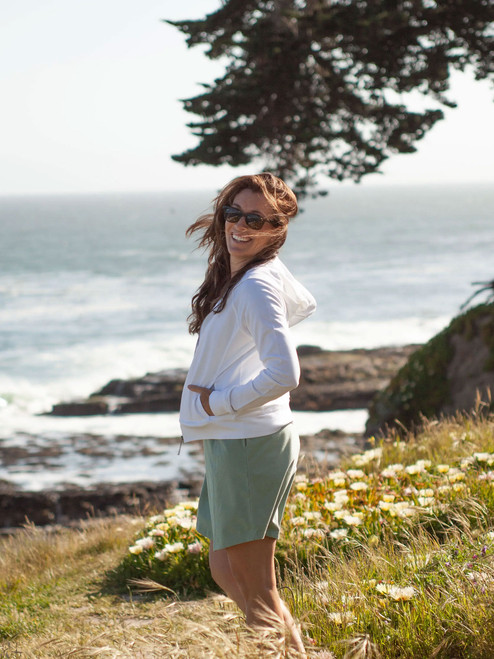 Woman standing outdoors near ocean wearing Inola Zip Up Hoodie Dusty in white