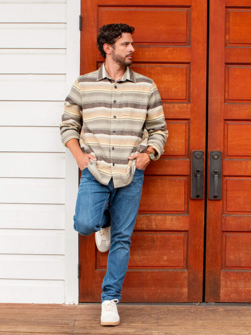 Man leaning against door outside during fall wearing the Miles Organic Cotton Big Shirt in natural stripes.