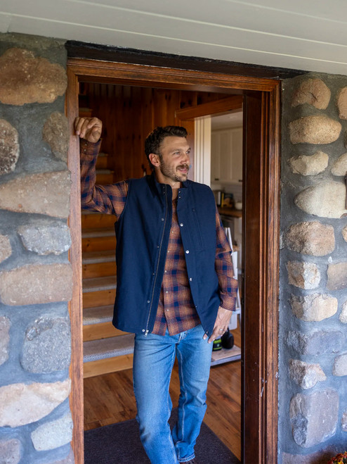 Man leaning in cabin doorway during fall wearing the Ranger Western Style Pearl Snap Shirt in navy plaid.