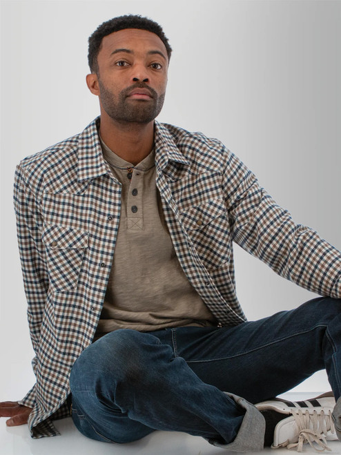 Man sitting wearing the Ranger Western Style Pearl Snap Shirt in brown plaid.