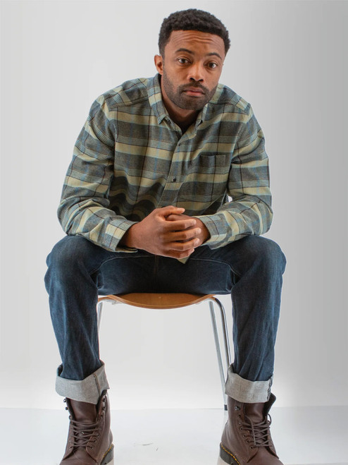Man sitting in chair wearing the Chase Organic Cotton Flannel Shirt in green plaid.