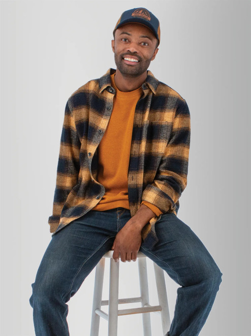 Man sitting in chair wearing the Chase Organic Cotton Flannel Shirt in navy plaid.
