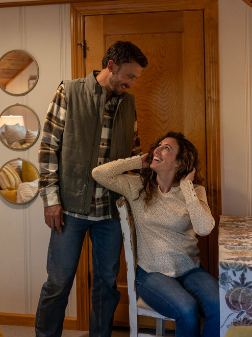 Man sitting indoors with woman wearing the Chase Organic Cotton Flannel Shirt in brown plaid.