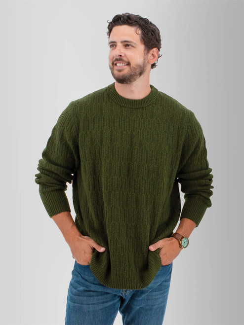 Man wearing the Wade Cable Knit Sweater in beetle green.