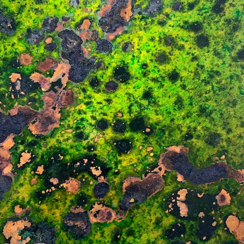 vibrant green patina copper sheet with a black and brown mottled oxidation pattern