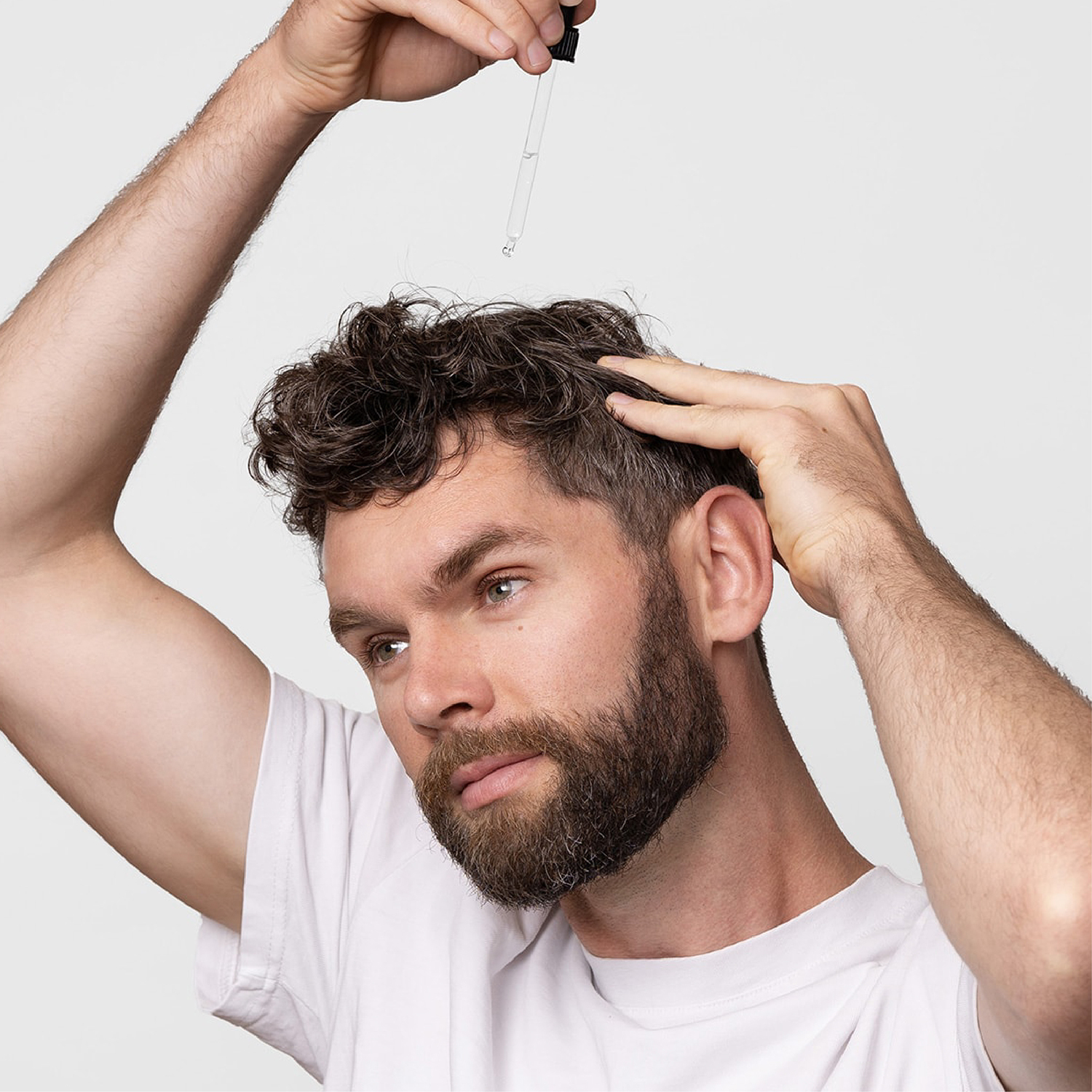 Man applying hair growth serum