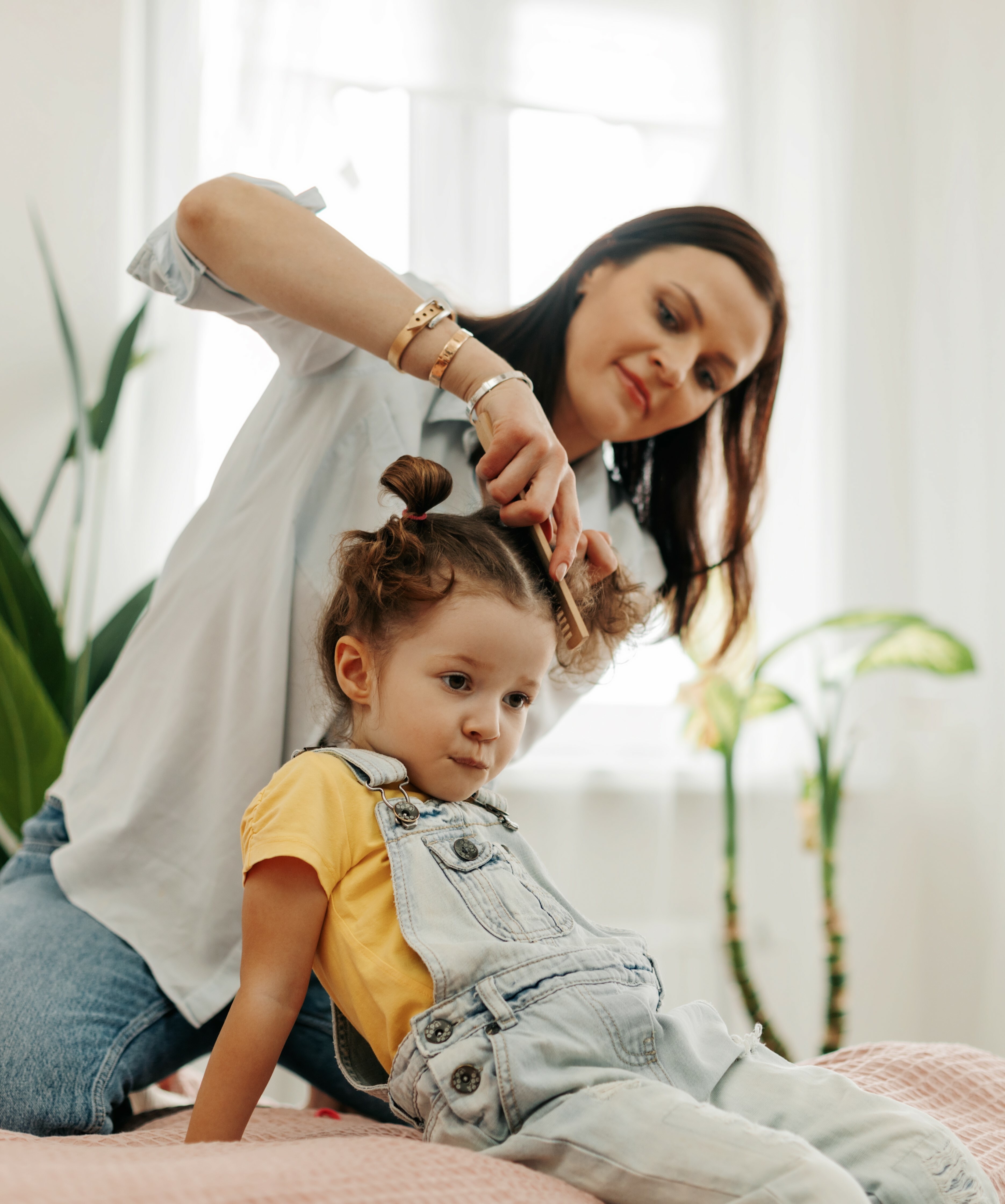 Mother brushing daughters hair