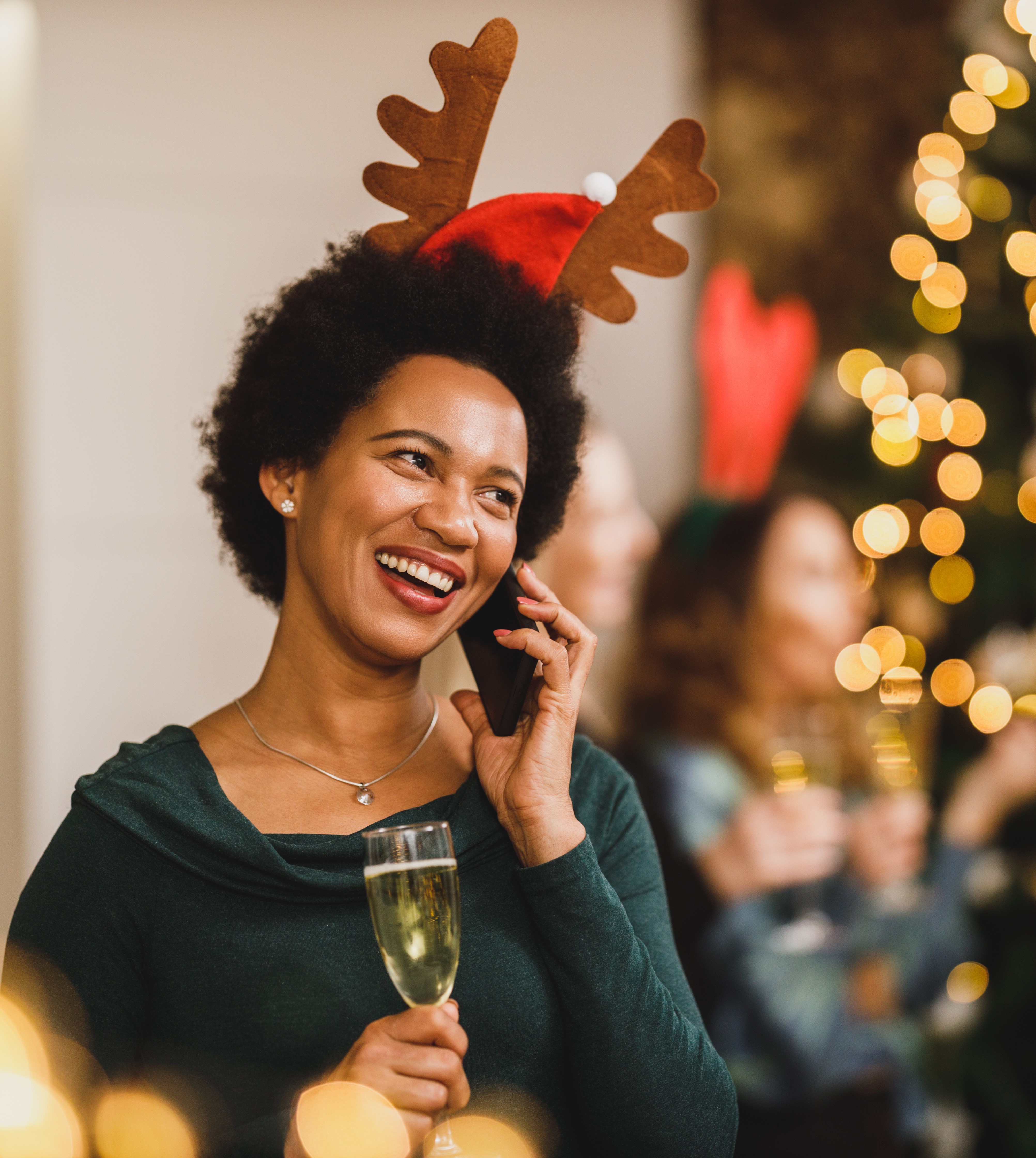Woman laughing next to christmas tree