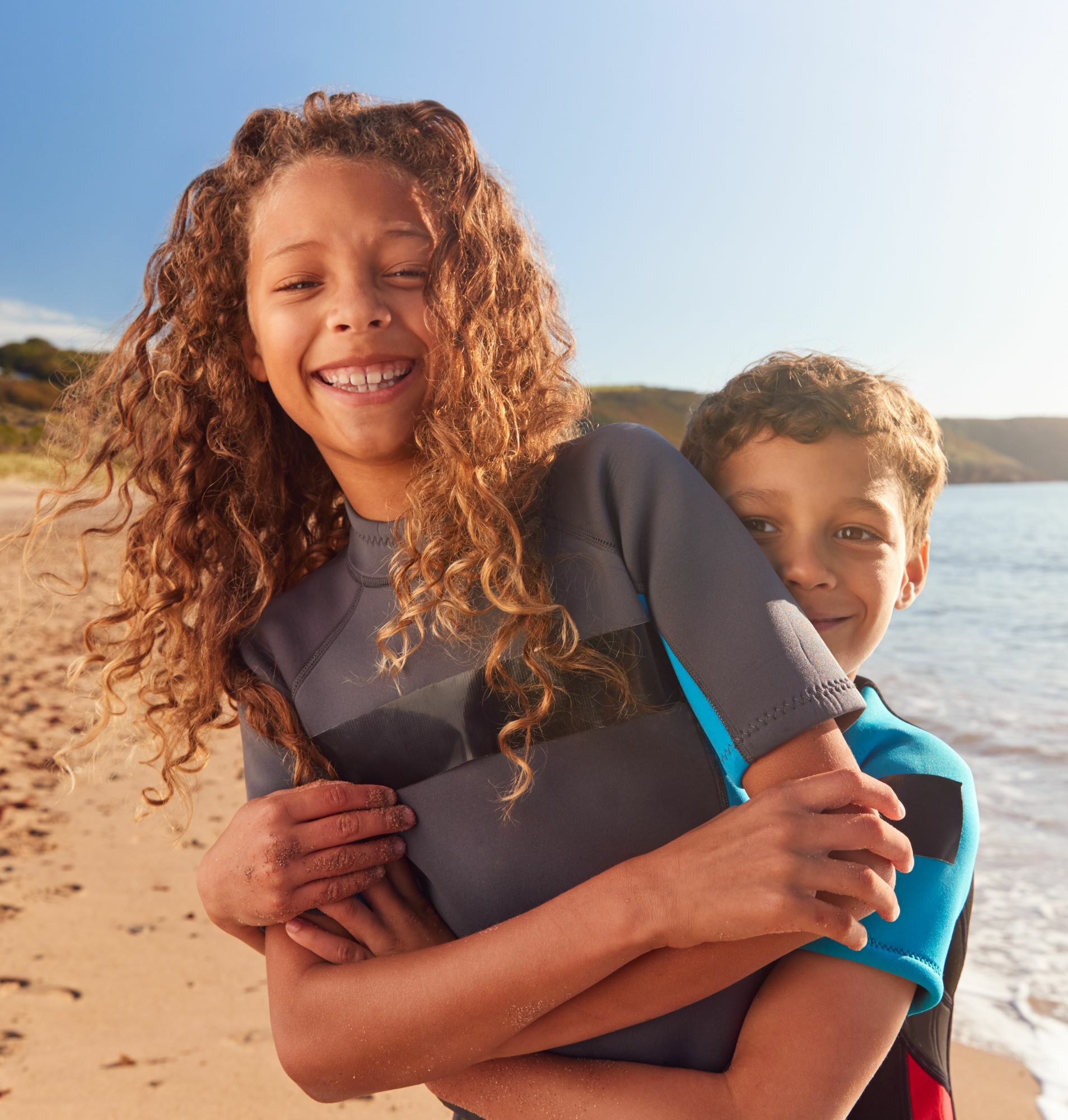 siblings hugging at beach