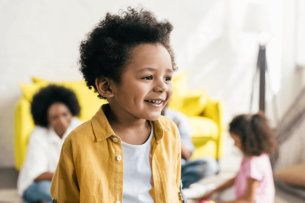 Young boy with bright shirt smiling