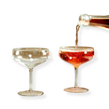 Maison Balzac Dot Coupes—A Playful Pair of Crystal Clear Glasses Decorated With Milky White Bubbles Or Transparent Pink Glasses With Amber Bubbles
