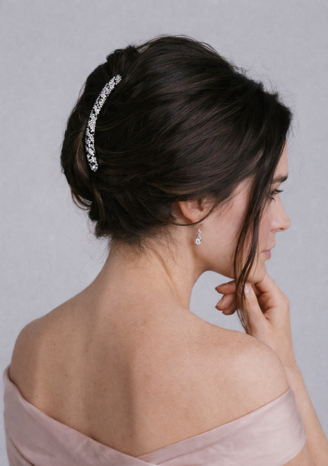 Élise Curve Crystal Hair Comb worn in hair: side view of dark updo with a slim clear crystal comb, hand at chin