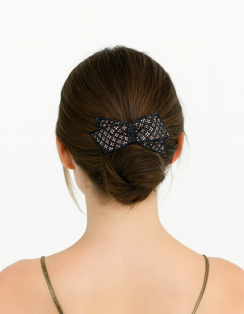 Woman seen from behind with a low bun and a dark bow-shaped accessory