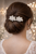 Woman seen from behind with a low updo and two small silver flower-shaped accessories