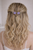 Woman with long wavy blonde hair pinned half-up with small purple flower-shaped accessories