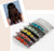 Collage of a woman with long dark wavy hair beside a stack of accessories with round red, yellow and teal stones