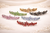 Floral Arc Crystal Hair Barrette: six of the colours on cream fabric: gold, green, grey, pink, blue and red