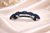 Celestial Sun Crystal Barrette: dark-blue barrette with crystal flower clusters, angled view on satin