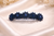 Celestial Sun Crystal Barrette: dark-blue crystal barrette lying on cream satin