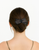 Woman seen from behind with a low bun and a dark bow-shaped accessory