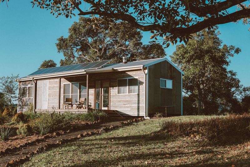 Off-grid wooden cabin with solar panels on the roof