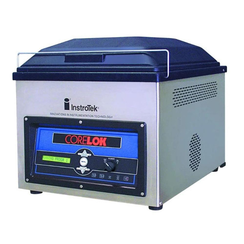 InstroTek CoreLok Asphalt Density Measurement System, a compact laboratory device with a digital display and control panel for measuring asphalt density.