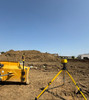 Spectra LR50W machine receiver on the blade mast of a dozer with an LL1505C laser on a tripod at a grading jobsite — customer photo from Rickey Bueno, Elite Excavation Pro's, who bought the setup from Contractors-Tools.com