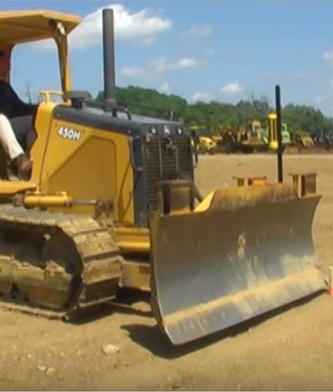 Crawler dozer grading a jobsite with a machine receiver mast on its blade