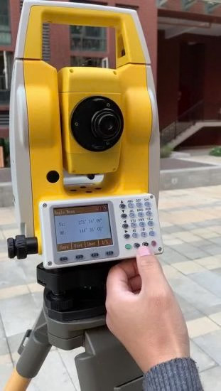 Northwest Instruments NTS03 total station on a tripod at a jobsite, operator pressing the alphanumeric keypad with the LCD angle display showing