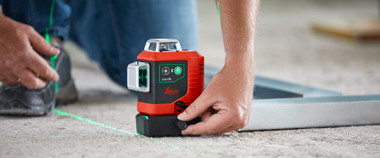 Contractor turning the fine adjustment knob on the base of a Leica Lino L6G to rotate the vertical green lines around the plumb point
