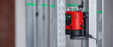 Leica Lino L6G mounted on a Twist 250 magnetic adapter on a drywall track with green lines across the studs