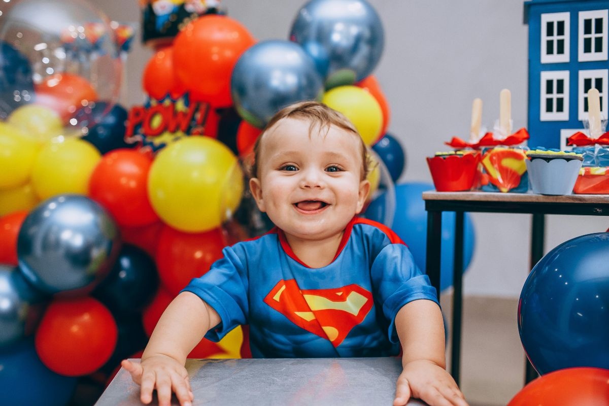 1. Idei petrecere copii acasa - copil costumat in SuperMan, baloane, decoratiuni
