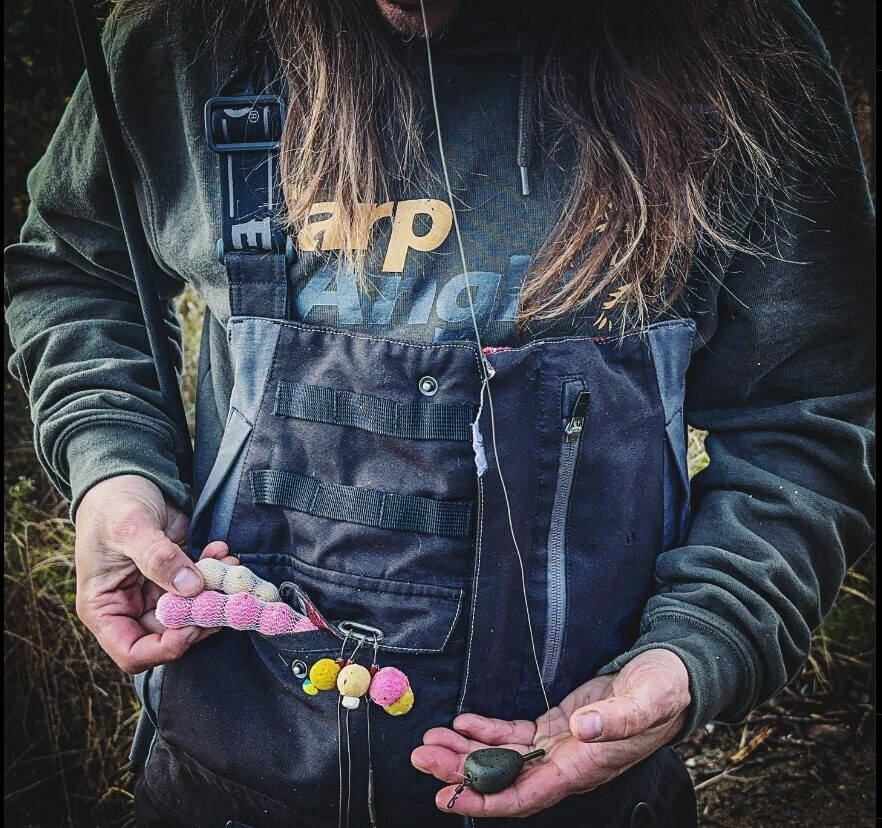 A carp angler holding boilies