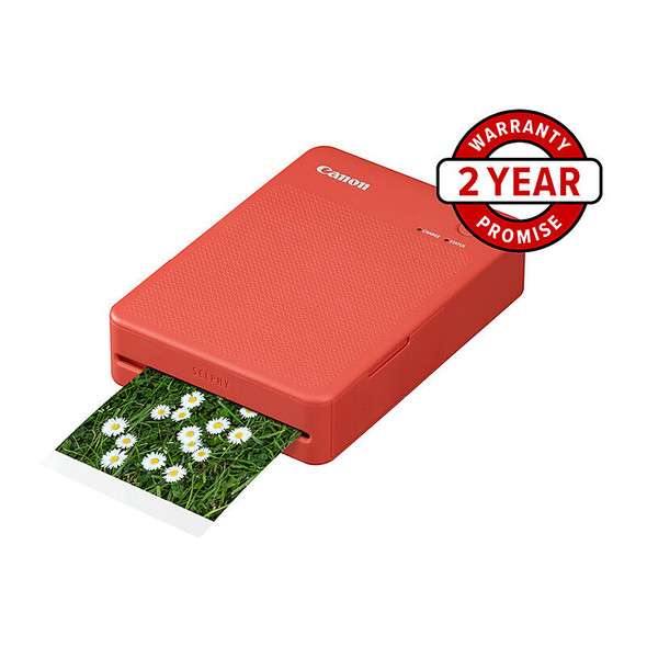Red Canon Selphy QX20 printer with green photo printing out, displaying white circular images.
